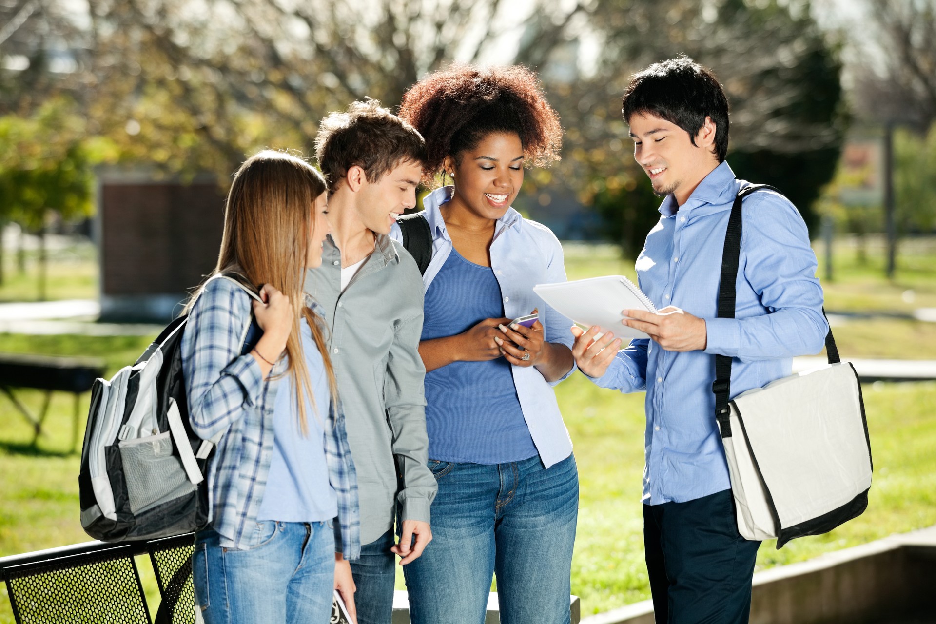 Young college students discussing over book in campus