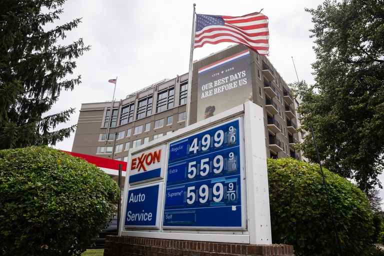 Gas prices are displayed on a sign at an Exxon station on Capitol Hill in Washington, D.C. on July 8, 2026. Behind it, a banner hangs from Heritage Foundation headquarters marking the 250th anniversary of the Declaration of Independence with the words "OUR BEST DAYS ARE BEFORE US." (Francis Chung/POLITICO via AP Images)